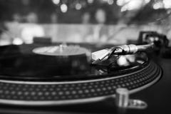 DJ que joga a música em uma plataforma giratória do vinil no partido do verão foto de stock royalty free DJ que joga a música em uma plataforma giratória do vinil no partido do verão foto de stock royalty free