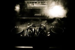 DJ закручивая, смешивая, и царапая в ночном клубе, руках управлений следа фишки dj различных на палубе dj, светах строба и тумане стоковое фото DJ закручивая, смешивая, и царапая в ночном клубе, руках управлений следа фишки dj различных на палубе dj, светах строба и тумане стоковое фото