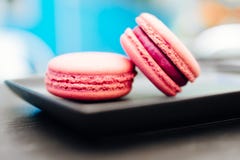 Doce, macarons frescos com caf? em um copo azul em uma tabela preta fotos de stock Doce, macarons frescos com caf? em um copo azul em uma tabela preta fotos de stock