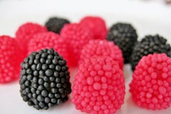 Doces da geleia sob a forma das framboesas, vermelho e preto em um fundo branco fotos de stock royalty free Doces da geleia sob a forma das framboesas, vermelho e preto em um fundo branco fotos de stock royalty free