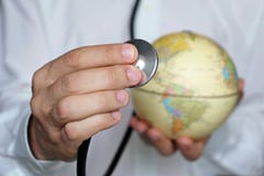 Docteur avec le stéthoscope et le globe dans des ses mains image stock Docteur avec le stéthoscope et le globe dans des ses mains image stock