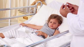 Docteur beau vérifiant la température de la petite fille banque de vidéos Docteur beau vérifiant la température de la petite fille banque de vidéos