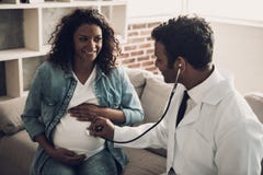 Docteur dans l'uniforme blanc consultant la femme enceinte image stock Docteur dans l'uniforme blanc consultant la femme enceinte image stock