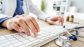 Docteur féminin dactylographiant sur l'ordinateur image libre de droits Docteur féminin dactylographiant sur l'ordinateur image libre de droits