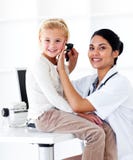 Docteur féminin de sourire contrôlant les oreilles de son patient images libres de droits Docteur féminin de sourire contrôlant les oreilles de son patient images libres de droits