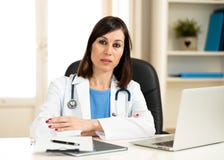 Docteur féminin réussi travaillant dans le bureau d'hôpital de clinique souriant et posant pour la caméra image libre de droits Docteur féminin réussi travaillant dans le bureau d'hôpital de clinique souriant et posant pour la caméra image libre de droits
