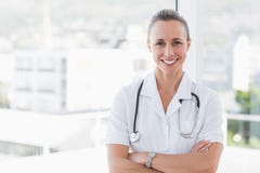 Docteur heureux souriant à l'appareil-photo avec des bras croisés Photographie stock libre de droits Docteur heureux souriant à l'appareil-photo avec des bras croisés Photographie stock libre de droits