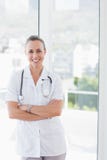 Docteur heureux souriant à l'appareil-photo avec des bras croisés Images libres de droits Docteur heureux souriant à l'appareil-photo avec des bras croisés Images libres de droits