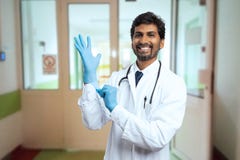 Docteur indien étant prêt en tant que port des gants chirurgicaux photos stock Docteur indien étant prêt en tant que port des gants chirurgicaux photos stock