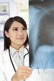 Doctor asiático que repasa radiografías fotografía de archivo libre de regalías Doctor asiático que repasa radiografías fotografía de archivo libre de regalías