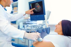 Doctor conducting the ultrasound procedure to pregnant woman stock photo Doctor conducting the ultrasound procedure to pregnant woman stock photo