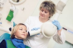 Dentist operates dental intraoral x-ray unit for tooth image with patient Stock Photography Dentist operates dental intraoral x-ray unit for tooth image with patient Stock Photography