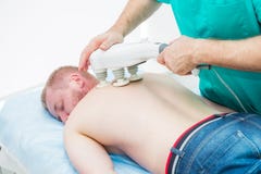 Doctor does transcranial magnetic stimulation, electrotherapeutic treatment of the back. A chiropractor treats patient`s thoracic stock photography Doctor does transcranial magnetic stimulation, electrotherapeutic treatment of the back. A chiropractor treats patient`s thoracic stock photography
