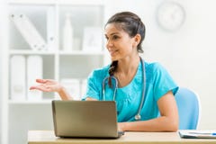 Doctor en su escritorio con el ordenador portátil imágenes de archivo libres de regalías Doctor en su escritorio con el ordenador portátil imágenes de archivo libres de regalías
