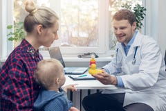 Doctor gives to child a duck toy during a medical visit royalty free stock images Doctor gives to child a duck toy during a medical visit royalty free stock images