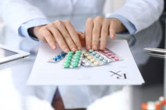 Doctor holding pack of different tablet blisters closeup. Life save service, legal drug store, prescribe medication