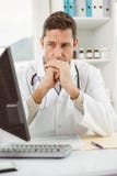 Doctor looking at computer in medical office royalty free stock photography Doctor looking at computer in medical office royalty free stock photography