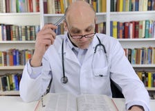 Doctor looking up information on medicine royalty free stock photo Doctor looking up information on medicine royalty free stock photo