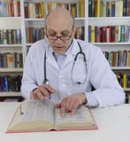 Doctor looking up information on medicine stock images Doctor looking up information on medicine stock images