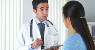 Doctor mexicano que escucha el paciente y que toma notas foto de archivo libre de regalías Doctor mexicano que escucha el paciente y que toma notas foto de archivo libre de regalías