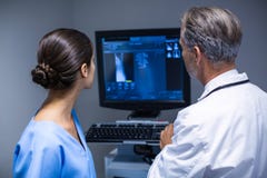 Doctor and nurse examining x-ray on computer stock photography Doctor and nurse examining x-ray on computer stock photography