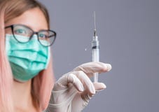 Doctor or nurse in face mask holding syringe stock photo Doctor or nurse in face mask holding syringe stock photo