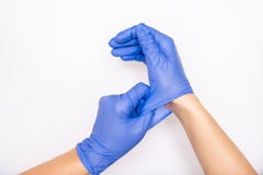 Doctor or nurse putting on blue nitrile surgical gloves, professional medical safety and hygiene for surgery and medical exam on