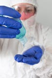 Doctor in protective clothing putting on sanitizing alcohol gel, hand disinfectant