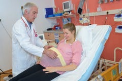 Doctor putting foetal monitoring belt on pregnant lady stock image Doctor putting foetal monitoring belt on pregnant lady stock image