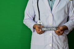 Doctor que se coloca en fondo verde Foco selectivo a disposición Alto texto del papel de Colesterol fotos de archivo libres de regalías Doctor que se coloca en fondo verde Foco selectivo a disposición Alto texto del papel de Colesterol fotos de archivo libres de regalías