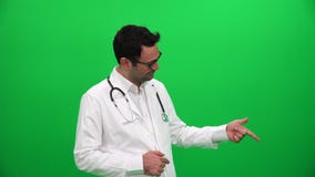 Doctor que señala el finger hasta esquina izquierda almacen de video Doctor que señala el finger hasta esquina izquierda almacen de video