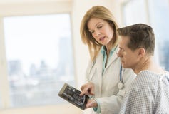 Doctor Showing Digital Tablet To Patient In Clinic stock images Doctor Showing Digital Tablet To Patient In Clinic stock images