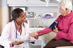 Doctor Taking Senior Female Patient's Blood Pressure