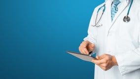 Doctor using a digital tablet on blue background. Global Technology in Healthcare And Medicine Concept stock photos Doctor using a digital tablet on blue background. Global Technology in Healthcare And Medicine Concept stock photos