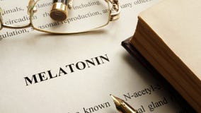 Document met woord Melatonin en boek op een lijst royalty-vrije stock fotografie Document met woord Melatonin en boek op een lijst royalty-vrije stock fotografie