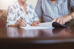 Documentos de firma de la mujer mayor con su marido imagenes de archivo Documentos de firma de la mujer mayor con su marido imagenes de archivo