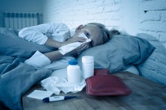 Doente de encontro da menina na cama que funde seu sentimento do nariz doente com a febre alta que está com uma gripe fria foto de stock royalty free Doente de encontro da menina na cama que funde seu sentimento do nariz doente com a febre alta que está com uma gripe fria foto de stock royalty free