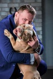 Dog bulli and her owner, her loving master who holds the dog in her arms, hugs and kisses. The dog feels good on the royalty free stock photo Dog bulli and her owner, her loving master who holds the dog in her arms, hugs and kisses. The dog feels good on the royalty free stock photo