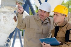 Dois construtores que apontam em algo fora foto de stock Dois construtores que apontam em algo fora foto de stock