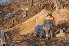 Dois equipam os trabalhadores do construtor que escavam no solo no poço da construção foto de stock Dois equipam os trabalhadores do construtor que escavam no solo no poço da construção foto de stock