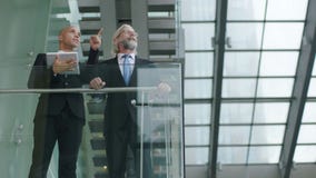 Dois executivos empresariais que discutem o negócio usando a tabuleta digital filme Dois executivos empresariais que discutem o negócio usando a tabuleta digital filme