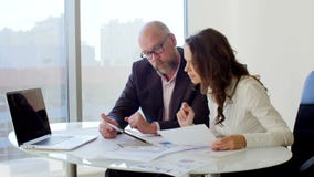 Dois executivos que trabalham com tabuleta Eles que discutem as ideias do negócio que sentam-se nas cadeiras no escritório claro video estoque Dois executivos que trabalham com tabuleta Eles que discutem as ideias do negócio que sentam-se nas cadeiras no escritório claro video estoque
