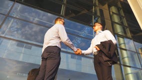 Dois homens de negócios que encontram-se perto do escritório e que cumprimentam-se Os colegas agitam as mãos no ambiente urbano N filme Dois homens de negócios que encontram-se perto do escritório e que cumprimentam-se Os colegas agitam as mãos no ambiente urbano N filme