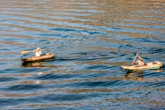 Dois homens em canoas de esconderijo subterrâneo no lago Atitlan, Guatemala imagem de stock royalty free Dois homens em canoas de esconderijo subterrâneo no lago Atitlan, Guatemala imagem de stock royalty free