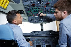 Dois homens no aprendiz da cabina do piloto de aviões que faz a pergunta foto de stock Dois homens no aprendiz da cabina do piloto de aviões que faz a pergunta foto de stock
