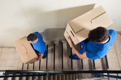 Dois motores que levam caixas de cartão na escadaria imagens de stock Dois motores que levam caixas de cartão na escadaria imagens de stock