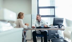 Doktor med patienten under konsultation i medicinskt kontor royaltyfri bild Doktor med patienten under konsultation i medicinskt kontor royaltyfri bild