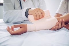 Doktoren behandeln Patienten mit Armverletzungen lizenzfreie stockfotografie Doktoren behandeln Patienten mit Armverletzungen lizenzfreie stockfotografie