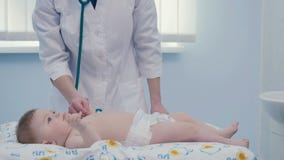 Doktorn lyssnar kroppen av pysen med stetoskopet lager videofilmer Doktorn lyssnar kroppen av pysen med stetoskopet lager videofilmer