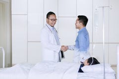 Doktorshandshaking med faderpatienten i sjukhus arkivfoto Doktorshandshaking med faderpatienten i sjukhus arkivfoto